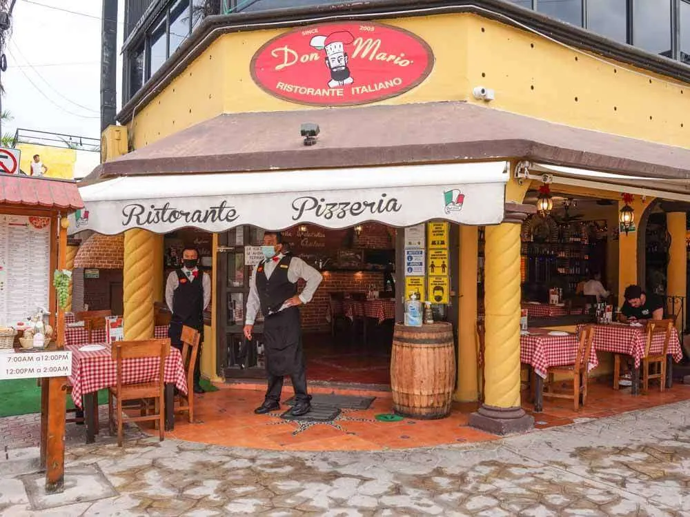 Waiters standing outside of Don Mario Pizza restaurant in Playa del Carmen Mexico