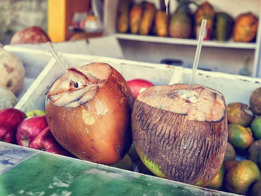 Fresh coconuts with a straw in them