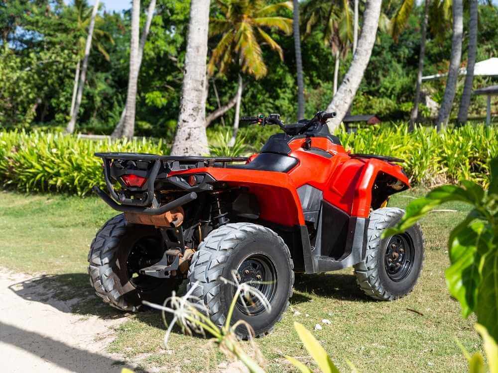 A red ATV parked on grass in Cozumel Mexico