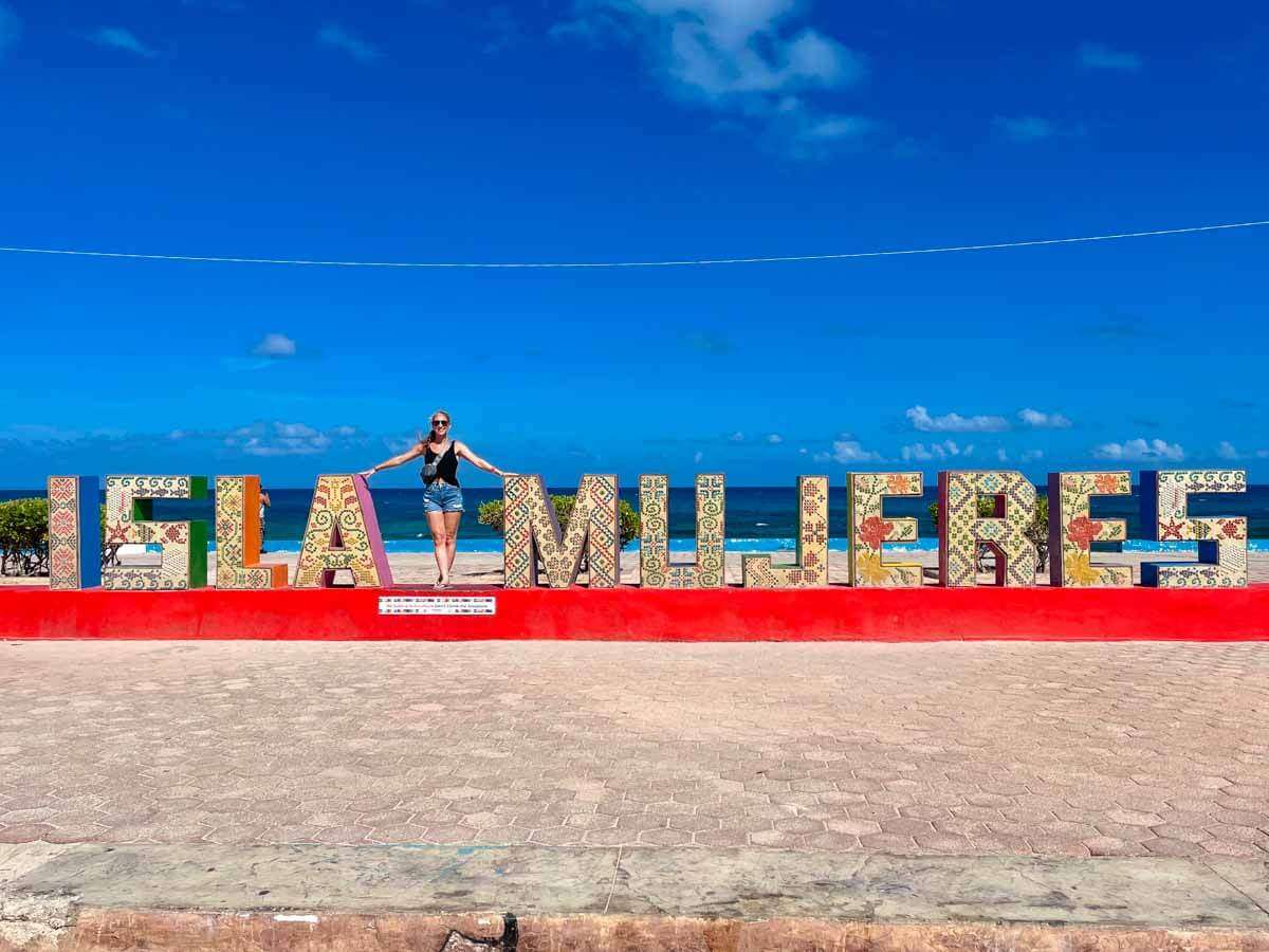 A person standing on the Isla Mujeres sign