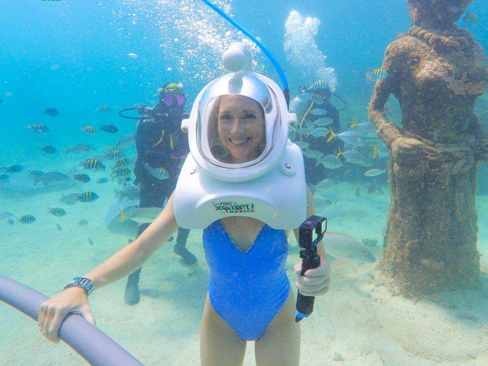 Me wearing an underwater helmet surrounded by fish on the Sea Trek excursion at Xcaret Park