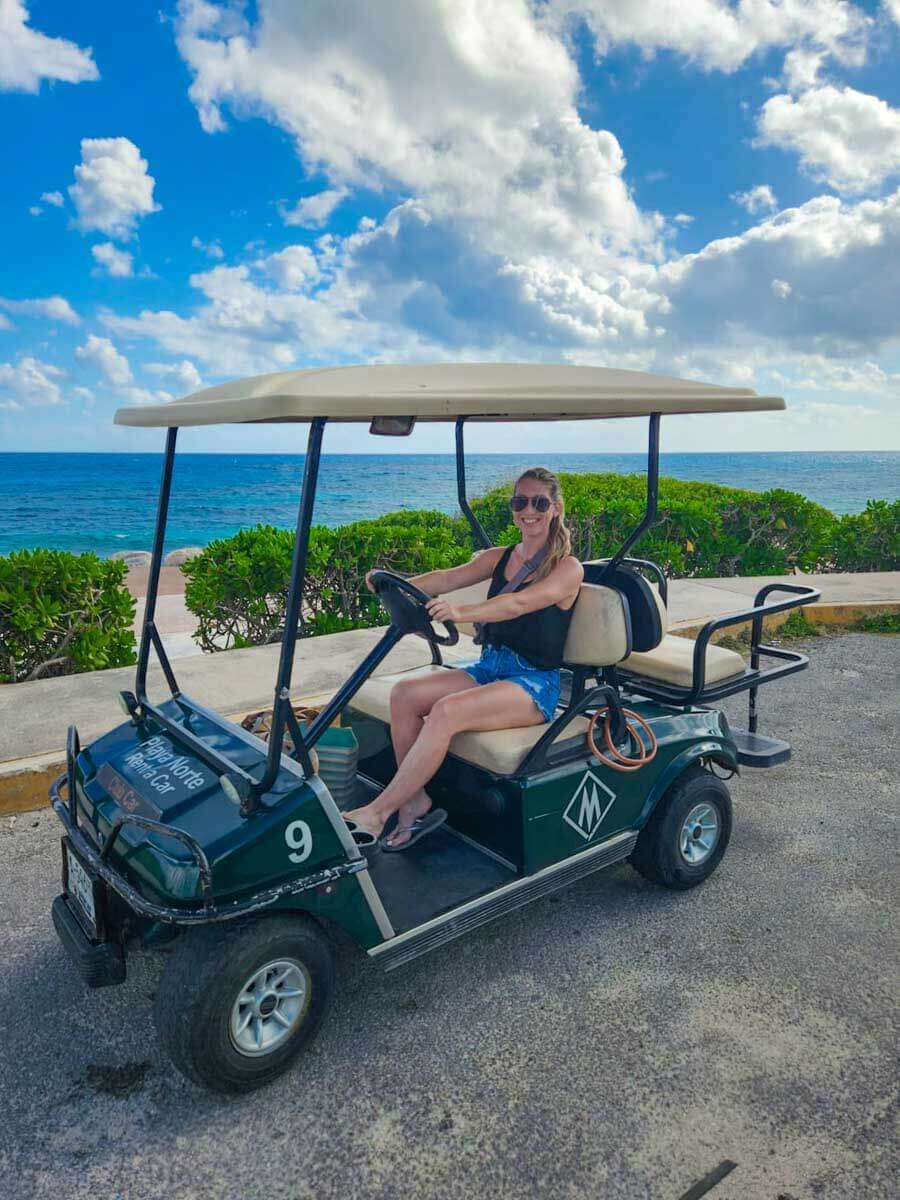 Me driving a golf cart in Isla Mujeres Mexico with the ocean in the background