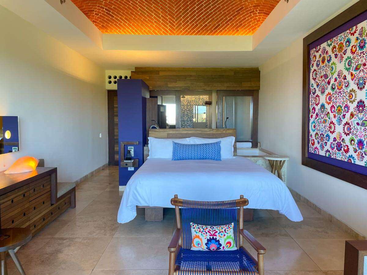 Hotel Xcaret Arte guestroom with a king-sized bed and furniture with purple accents