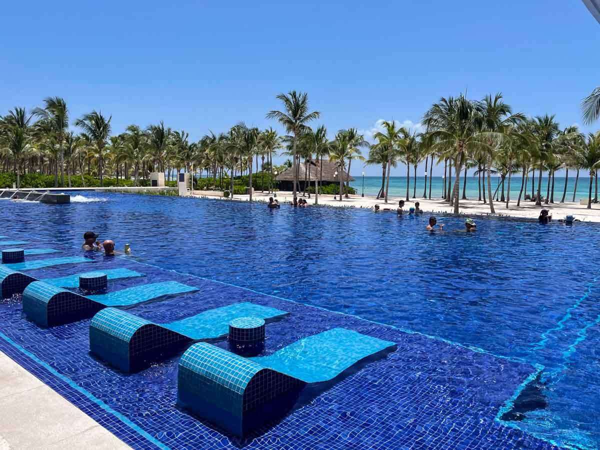 An infinity pool at Barcelo Maya Riviera Resort with people in it