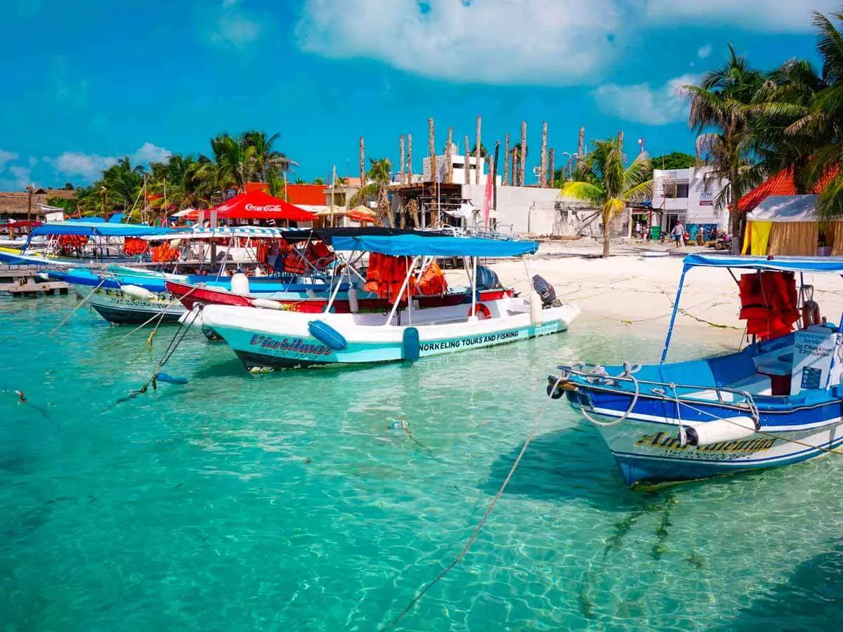 Small fishing boats anchored off the beach in Isla Mujeres Mexico