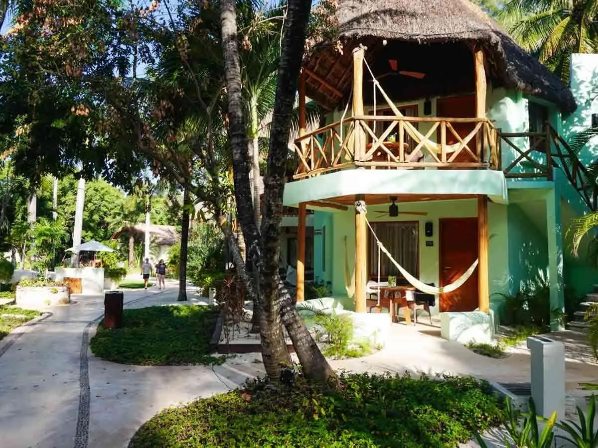 Two-story bungalows at Mahekal Beach Resort Playa del Carmen with hammocks and surrounded by trees