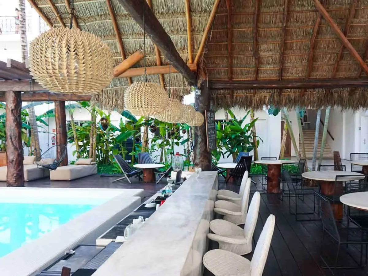 The pool bar with bar stools and tables at Hotel HM Playa del Carmen Hotel