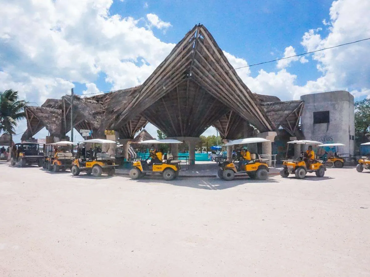 A row of golf cart taxis lined up in front of the ferry terminal in Holbox Mexico