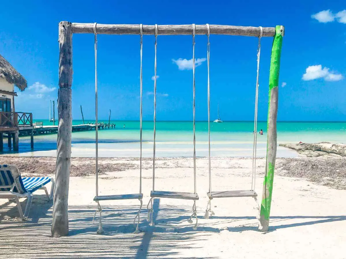 3 wooden swings on the beach in Holbox Mexico