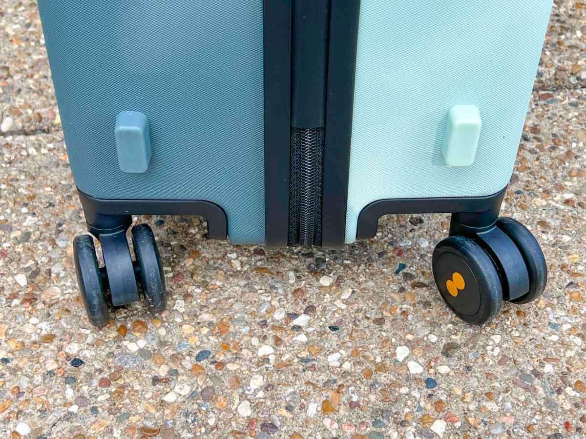 A close up of the 360° Spinner Wheels on the bottom of a Level8 Voyageur suitcase on a sidewalk