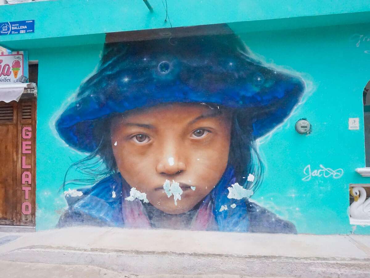 A street mural of a child in a blue hat in Holbox Mexico