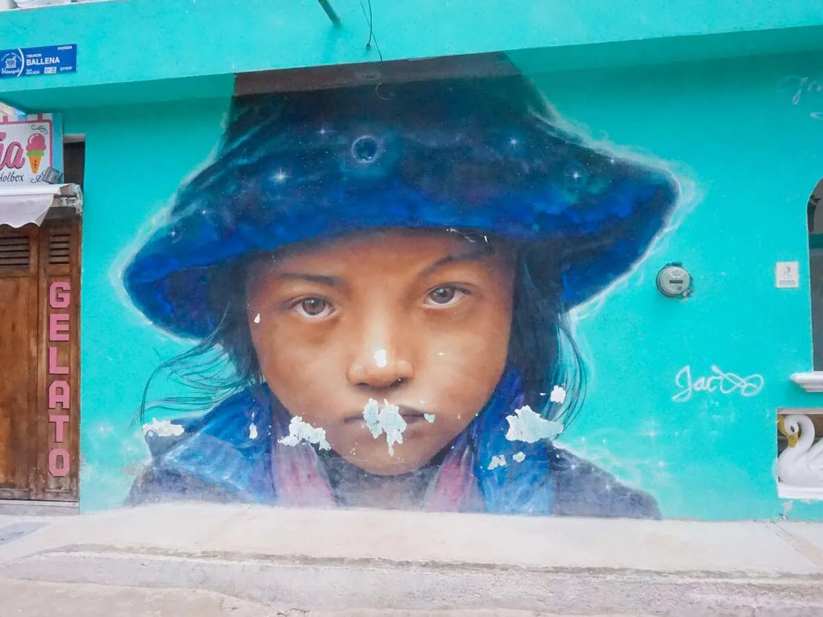 A street mural of a child in a blue hat in Holbox Mexico