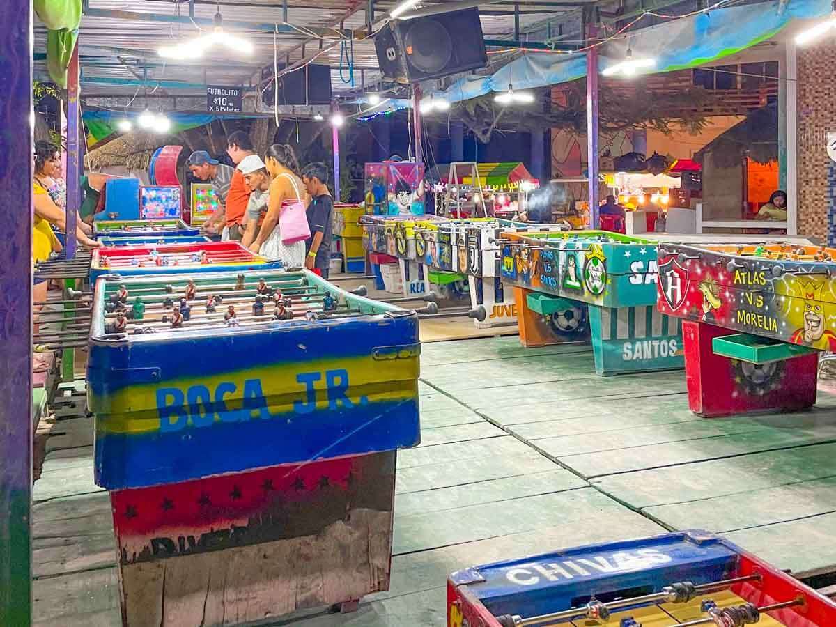 People playing on pinball machines at Parque Central in Holbox Mexico