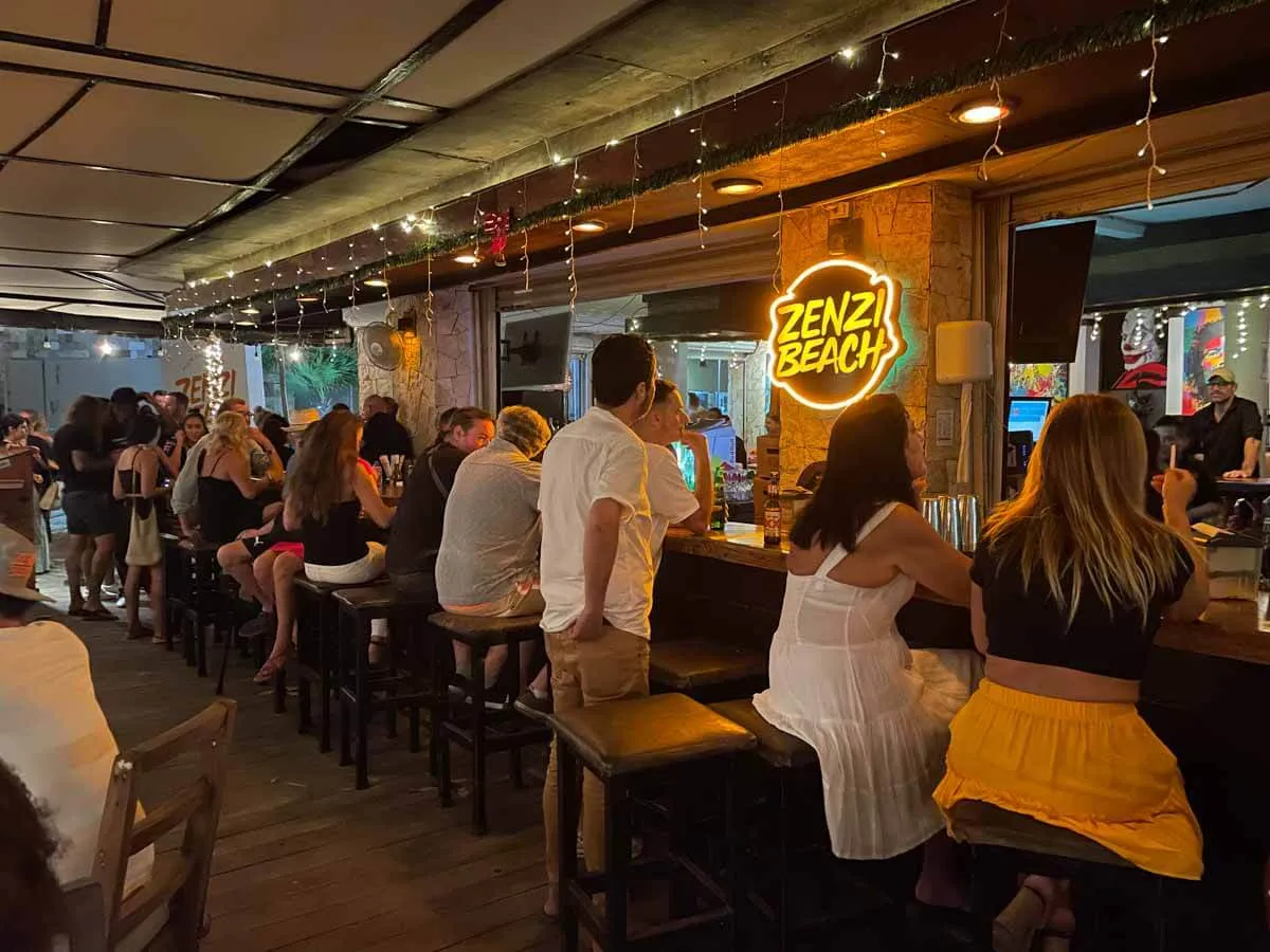 People sitting at the bar at Zenzi Beach