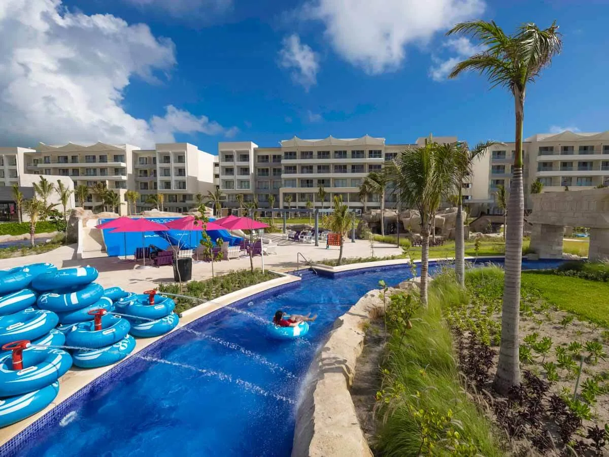 A resort in Cancun with people floating down the lazy river