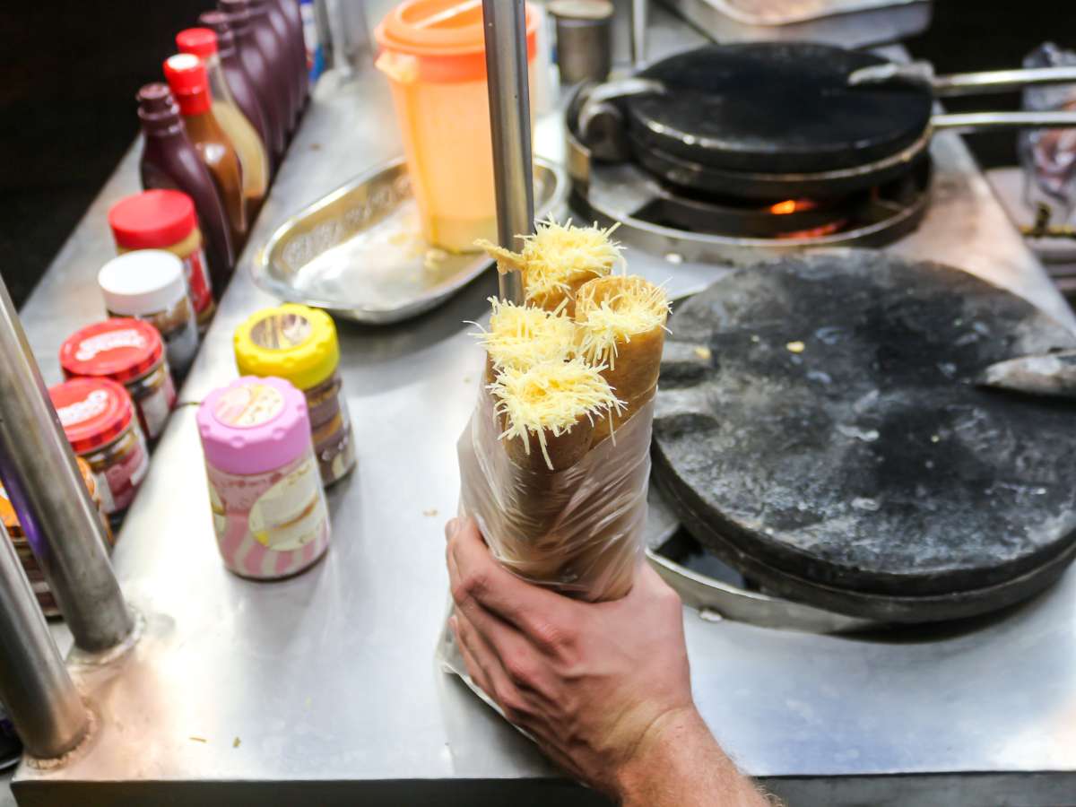 A marquesitas cart with fillings next to a hot plate