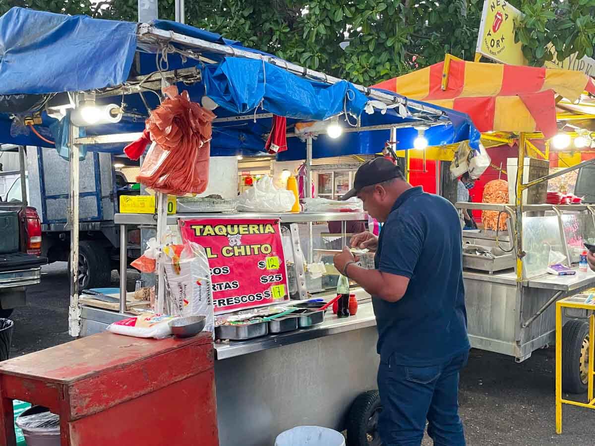 A man ordering from a taco stand in Playa del Carmen Mexico