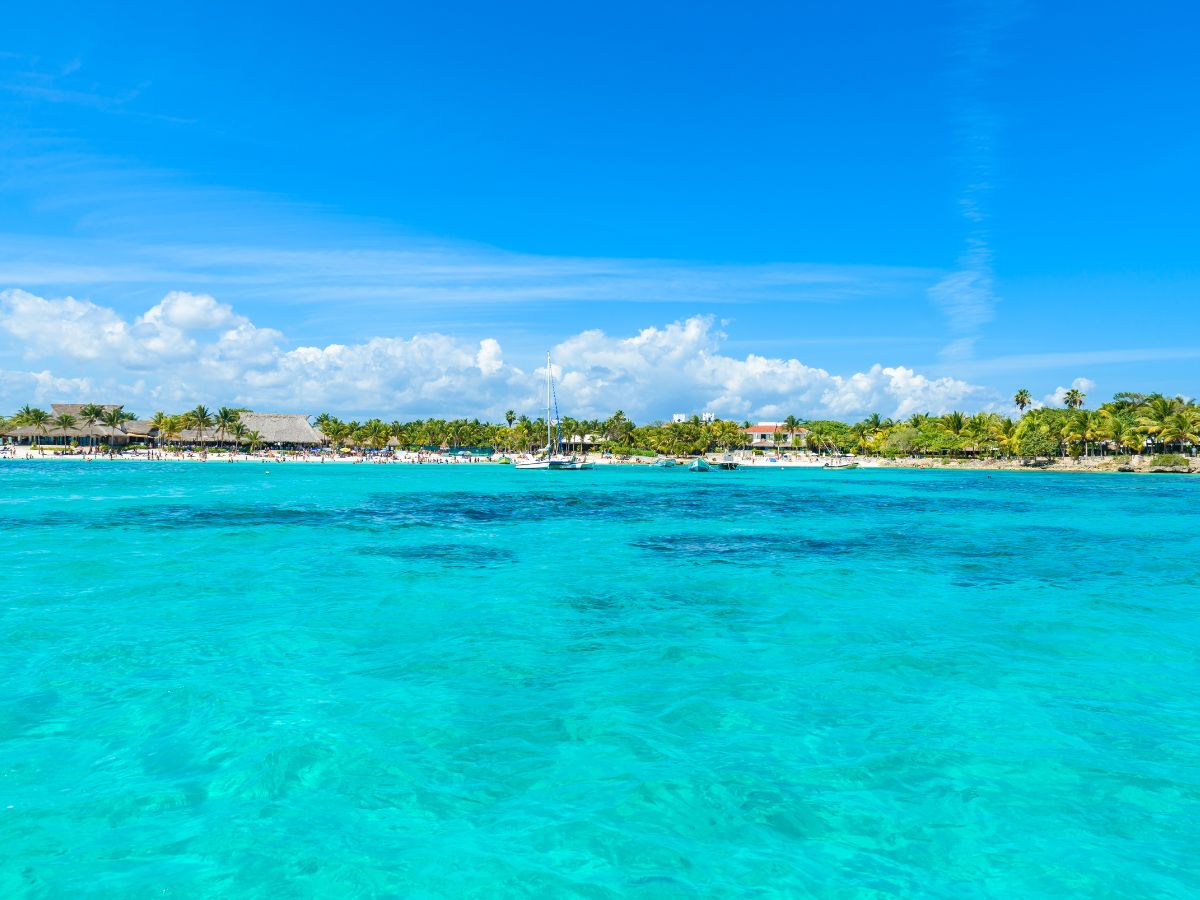 Crystal clear waters of Paamul Beach with palm trees in the background